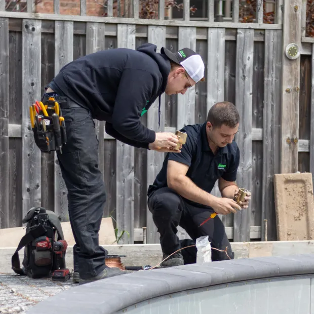 two electricians bonding a pool