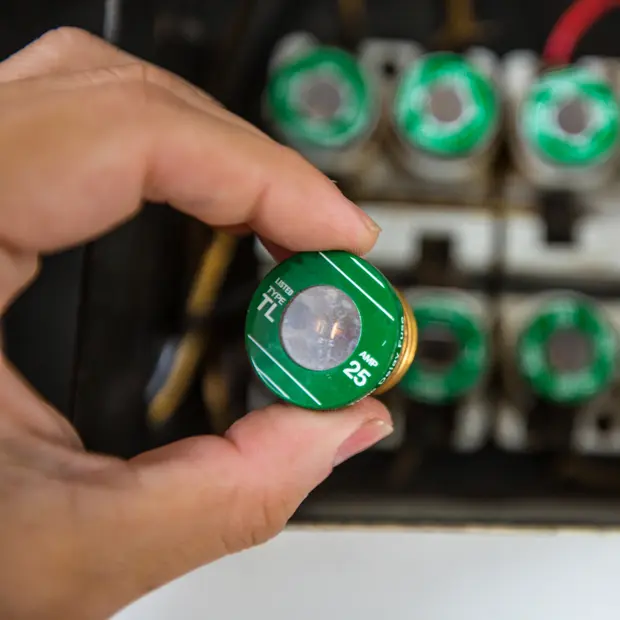 hand holding a fuse from a fuse panel